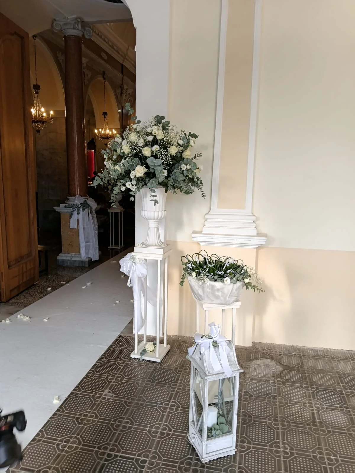 Addobbo reale con rose bianche ed eucalipto su una colonna all’ingresso della chiesa
